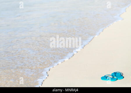 Türkis Flip Flops an einem tropischen Strand Stockfoto