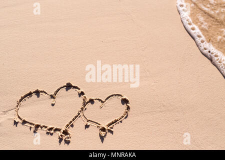 Herzen auf Sand und Meer wave gezeichnet Stockfoto