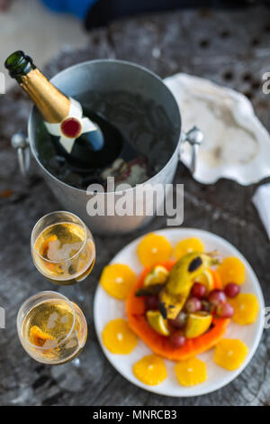 Zwei Gläser mit Champagner und Obst auf Holz vintage Fach für besondere Anlässe oder Feier serviert. Stockfoto