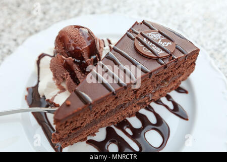 Schokoladenkuchen im Stil der Sachertorte plus eine Kugel aus Schokolade, Eis Stockfoto