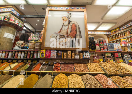 Ein Schild über dem Gewürz Behälter bei Store zeigt einen türkischen Mann hält eine Schachtel mit türkischen Köstlichkeiten, Istanbul Spice Bazaar in der Türkei Stockfoto