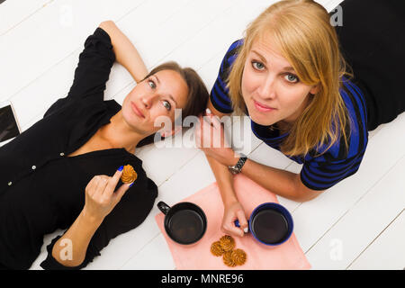 Zwei Mädchen auf weißem Holz- Hintergrund, Ansicht von oben, Studio, Beleuchtung Stockfoto