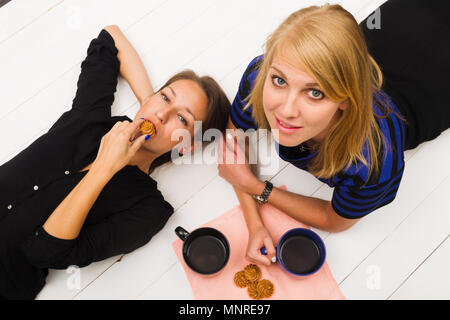 Zwei Mädchen auf weißem Holz- Hintergrund, Ansicht von oben, Studio, Beleuchtung Stockfoto