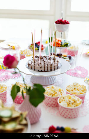 Kuchen, Süßigkeiten, Marshmallows, Popcorn, Früchte und andere Süßigkeiten auf Desserttellern tisch Kindergeburtstag Stockfoto