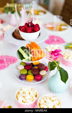 Kuchen, Süßigkeiten, Marshmallows, Popcorn, Früchte und andere Süßigkeiten auf Desserttellern tisch Kindergeburtstag Stockfoto