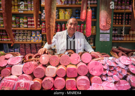 Ein lächelndes Männchen Kaufmann steht hinter Zähler mit verschiedenen Arten von Fleisch zum Verkauf in Istanbul, Spice Bazaar in der Türkei Stockfoto