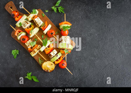 Vegetarisch grillen. Vegetarische Spieße mit Halloumi Käse und Gemüse auf schwarzem Hintergrund, kopieren. Stockfoto