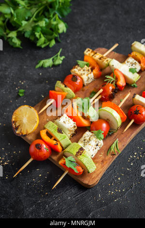Vegetarisch grillen. Vegetarische Spieße mit Halloumi Käse und Gemüse auf schwarzem Hintergrund, kopieren. Stockfoto