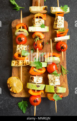 Vegetarisch grillen. Vegetarische Spieße mit Halloumi Käse und Gemüse auf schwarzem Hintergrund, kopieren. Stockfoto