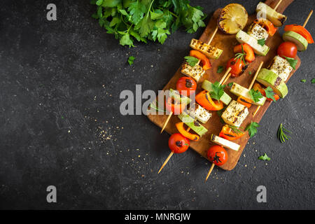 Vegetarisch grillen. Vegetarische Spieße mit Halloumi Käse und Gemüse auf schwarzem Hintergrund, kopieren. Stockfoto