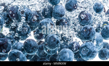 Heidelbeeren in das Wasser sinken mit Luftblasen weißer Hintergrund Stockfoto