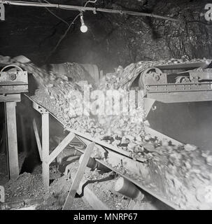 1950, historische, frisch gegraben Kohle durchgeführt werden u auf Förderbändern in einem Bergwerk, England, Großbritannien transportiert oder. Stockfoto