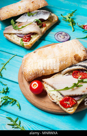 Sandwich mit Hering und Zwiebel auf Blau Holztisch. Stockfoto
