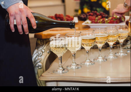 Der Kellner gießt Champagner auf dem Buffet. Sekt auf der Party. Stockfoto