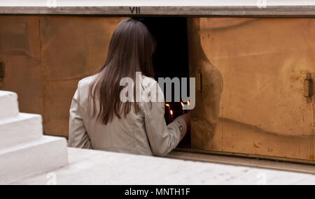 Frau Beleuchtung Gebet Kerze aka, Opfer oder Memorial Kerzen in der Kirche. Stockfoto