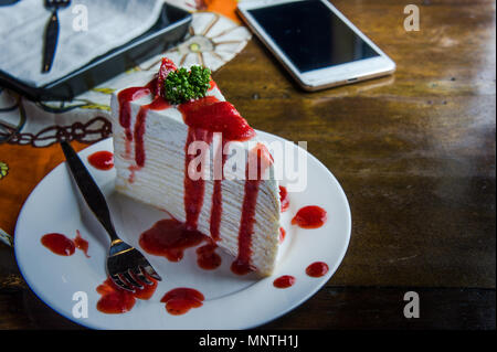 Erdbeere crape Kuchen auf Holz Tisch im Café, Nachtisch lecker Kuchen Stockfoto