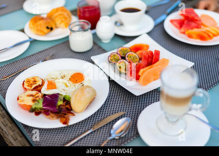 Köstliches Frühstück mit Spiegelei, Speck, Gemüse, Obst Stockfoto