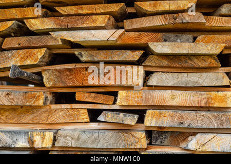 Stapel gestapelt Bauholz. Getrocknete Holz Bretter mit einem Knacken. Verschiedene Arten von Holz. Close-up. Stockfoto