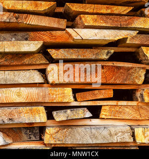 Stapel gestapelt Bauholz. Getrocknete Holz Bretter mit einem Knacken. Verschiedene Arten von Holz. Platz. Getönt. Close-up. Stockfoto