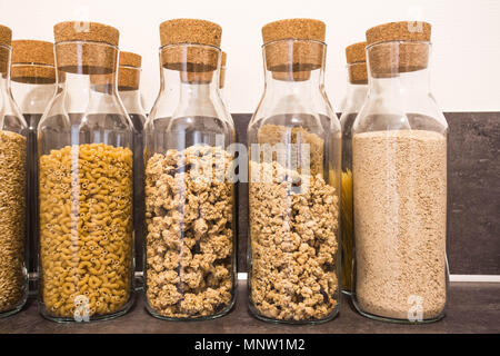 Sammlung von Vollkornprodukten, Linsen, Sojabohnen und rote Bohnen in storage jars auf Küche ländlichen Tabelle. Stockfoto