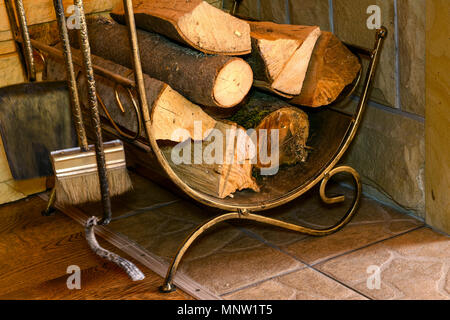 Stapel von Brennholz und Kamin Zubehör stehen in der Nähe der Hauswand. Close-up. Stockfoto