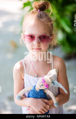 Kleines Mädchen mit einem Spielzeug in rosa Sonnenbrille im Freien auf Sommer Tag Stockfoto