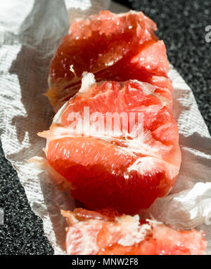 Rubinrot Segmente von Pampelmusen und Grapefruits: Tief rote Grapefruit geöffnet und bereit leuchtet in der Sonne zu essen. Stockfoto