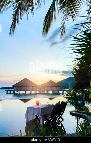 Romantische luxuriöse Abendessen im Tropical Resort am Sonnenuntergang Stockfoto