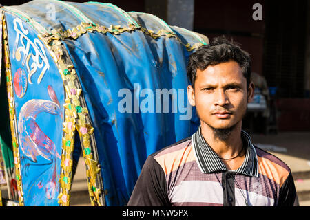 Dhaka, Bangladesh, 24. Februar 2017: Porträt eines lächelnden Trishaw Fahrer stolz neben seinem Fahrzeug in Dhaka, Bangladesch posing Stockfoto