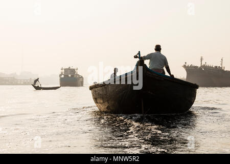 Dhaka, Bangladesh, 24. Februar 2017: rudern Boote auf dem Fluss Buriganga in Dhaka, Bangladesch und im Hintergrund die alte Werft Stockfoto