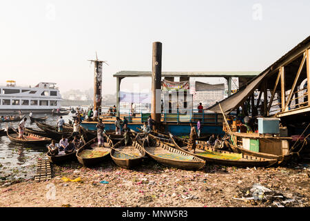 Dhaka, Bangladesh, 24. Februar 2017: Kleine Ruderboote dienen als Taxi zwischen den beiden Ufern des Flusses auf der Buriganga Fluss in Dhaka, Bangladesch, im Hinterg Stockfoto