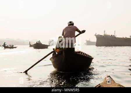 Dhaka, Bangladesh, 24. Februar 2017: rudern Boote auf dem Fluss Buriganga in Dhaka, Bangladesch und im Hintergrund die alte Werft Stockfoto