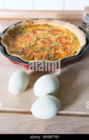 Frische Quiche mit grünen Eier, Tomaten und Frühlingszwiebeln Stockfoto