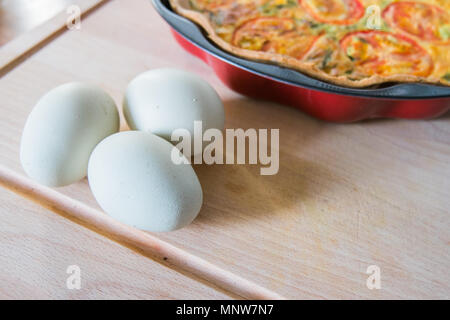 Frische Quiche mit grünen Eier, Tomaten und Frühlingszwiebeln Stockfoto