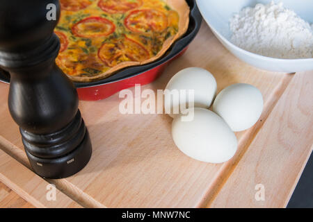 Frische Quiche mit grünen Eier, Tomaten und Frühlingszwiebeln Stockfoto