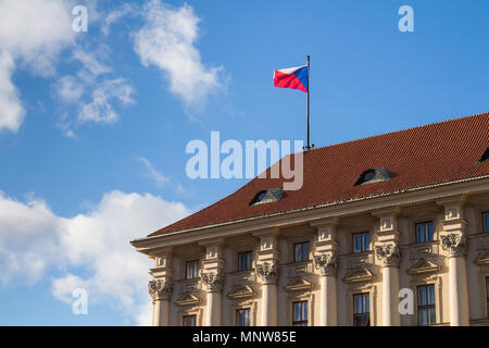 Tschechische Fahne im Wind auf dem Dach des Ministeriums für Auswärtige Angelegenheiten in Prag, Tschechische Republik. Blauer Himmel mit weißen Wolken. Stockfoto