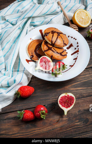 Pfannkuchen mit Feigen und Erdbeeren, die auf weiße Platte Nahaufnahme. Stockfoto