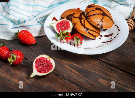 Pfannkuchen mit Feigen und Erdbeeren, die auf weiße Platte Nahaufnahme. Stockfoto