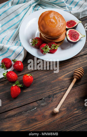 Pfannkuchen mit Feigen und Erdbeeren, die auf weiße Platte Nahaufnahme. Stockfoto