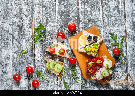 Auswahl an Sandwiches mit verschiedenen Toppings auf weißem Hintergrund. Stockfoto