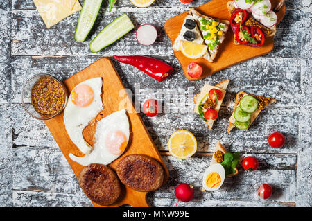 Auswahl an Sandwiches mit verschiedenen Toppings auf weißem Hintergrund. Stockfoto