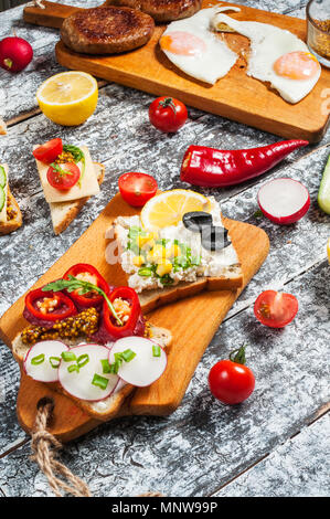 Auswahl an Sandwiches mit verschiedenen Toppings auf weißem Hintergrund. Stockfoto