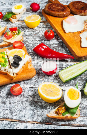 Auswahl an Sandwiches mit verschiedenen Toppings auf weißem Hintergrund. Stockfoto