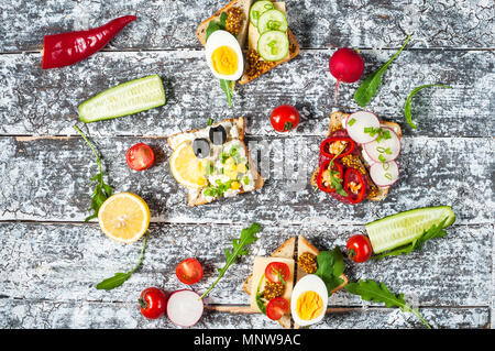 Auswahl an Sandwiches mit verschiedenen Toppings auf weißem Hintergrund. Stockfoto