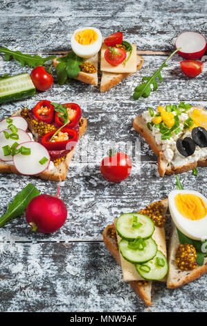 Auswahl an Sandwiches mit verschiedenen Toppings auf weißem Hintergrund. Stockfoto