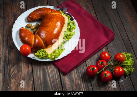 Vollkornbrot Bagel mit grünem Pesto, frisches Gemüse, Käse, Tomaten auf einem alten Holztisch. Stockfoto