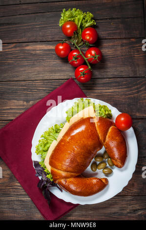 Vollkornbrot Bagel mit grünem Pesto, frisches Gemüse, Käse, Tomaten auf einem alten Holztisch. Stockfoto