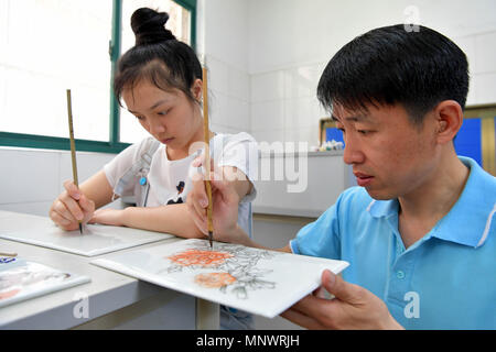 Nanchang, China's Jiangxi Province. 20 Mai, 2018. Li Huanqiu (R) und einem schwerhörigen Schüler Malen zusammen an Qiyin Schule in Nanchang, China's Jiangxi Province, 20. Mai 2018. Der 48-jährige Li verloren Anhörung im Alter von zwei Jahren. Nach dem Studium von der Universität, er wurde ein kunstlehrer an Qiyin Schule und seine Art Studio gegründet mit Unterstützung der Schule. So weit, Li hat in der Schule für 22 Jahre gearbeitet. Credit: Peng Zhaozhi/Xinhua/Alamy leben Nachrichten Stockfoto