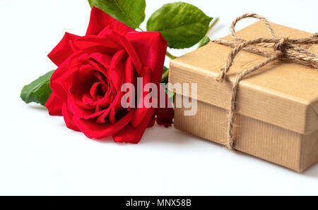 Valentines Tag. Rose rote Blume und ein Handwerk Recyclingpapier Geschenkbox auf weißem Hintergrund Stockfoto