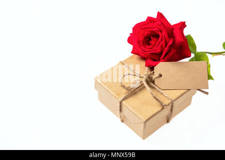 Valentines Tag. Rose rote Blume und einem Geschenkkarton mit einer leeren tag auf einem weißen Hintergrund, Platz für Text Stockfoto